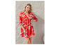 Une femme porte une robe rouge avec un motif abstrait blanc.