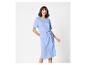 Femme souriante portant une robe bleue avec un nœud à la taille.