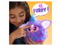 Fille jouant avec un Furby violet aux accents bleus sur fond jaune.