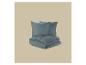 Parure de lit bleue et deux oreillers sur fond beige.