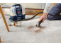 Nettoyeur de tapis portable enlevant les taches de café d'un tapis clair.