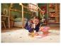 Une fille joue avec le set de pique-nique en bois LUPILU sur le tapis.
