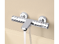 Mitigeur de douche chromé avec thermostat, eau coulant dans une baignoire.