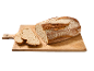 Pain rustique fraîchement cuit, partiellement tranché, sur une planche à découper en bois.