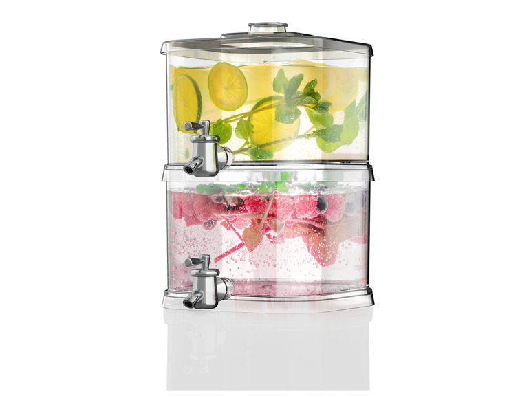 Un distributeur en verre avec un robinet, rempli d'eau, de citron et de baies.