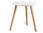 Une table basse ronde blanche avec des pieds en bois.