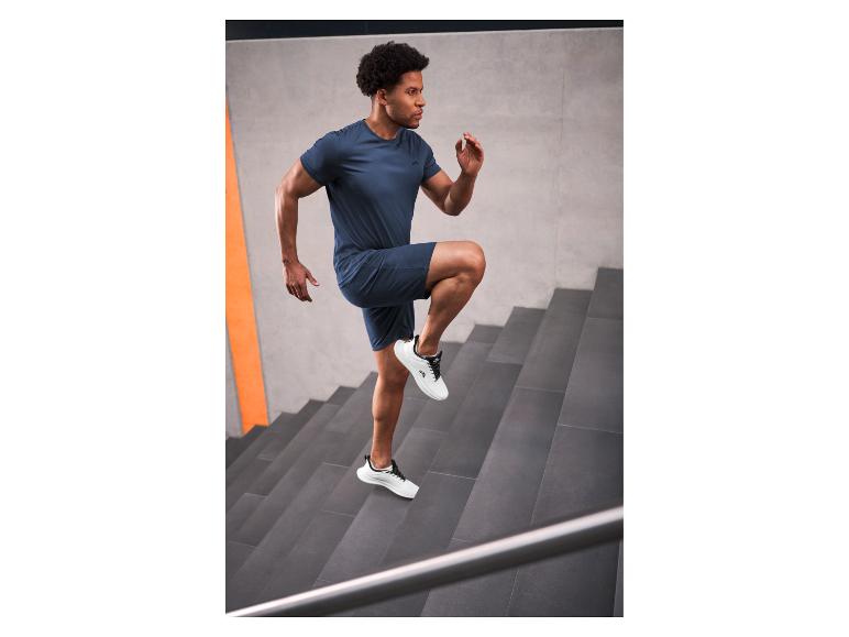 Homme en tenue de sport bleu marine montant des escaliers