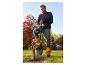 Homme en veste polaire noire et pantalon de travail orange-gris avec pelle dans le jardin.