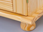 Une armoire en bois avec une porte à panneau et des pieds tournés.