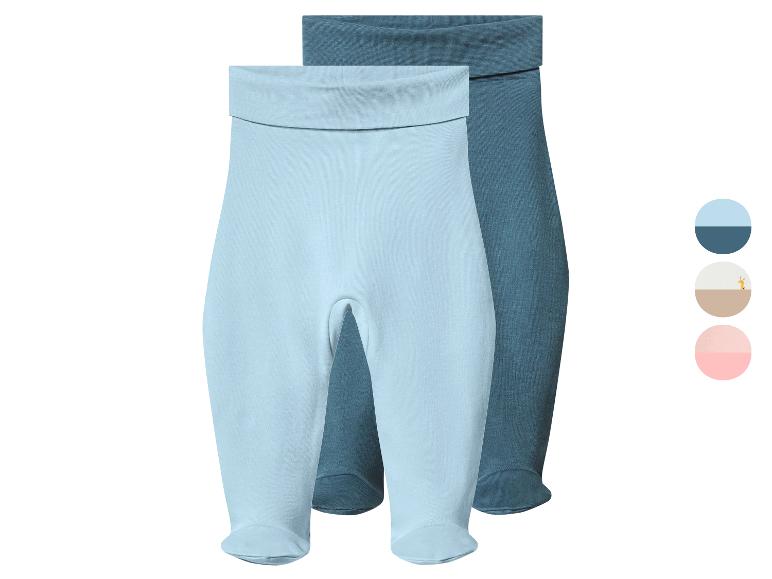 Deux pantalons de bébé bleus et bleu foncé avec pieds, avec des échantillons de couleur.