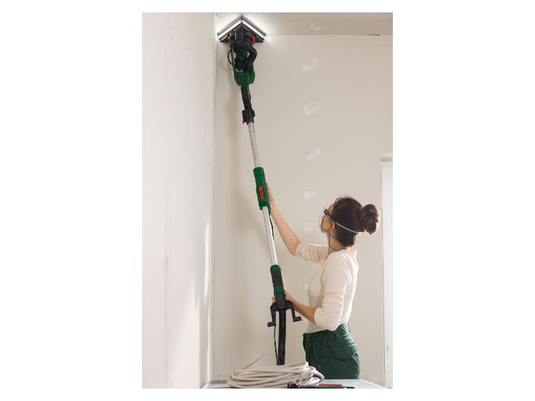 Une femme utilise une ponceuse Bosch pour travailler au plafond.