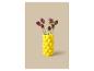 Vase jaune avec des fleurs violettes sur fond beige.
