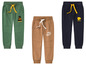 Trois pantalons de survêtement pour garçons avec des designs différents : vert avec 'Adventure', marron avec 'Stay Wild' et bleu foncé avec 'Forest Friends'.
