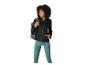 Femme souriante en veste polaire noire et leggings de sport turquoise avec un sac à dos.