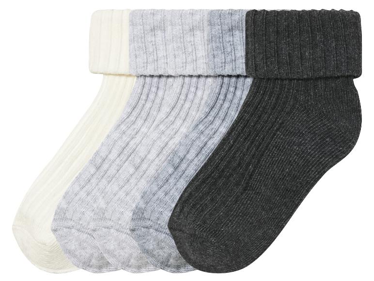 Trois paires de chaussettes en blanc, gris et noir.