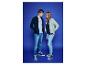 Deux jeunes portent des vestes et des jeans, sur un fond bleu.
