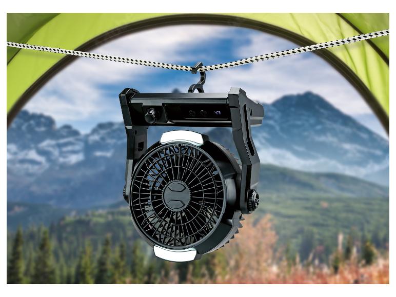 Ventilateur de camping avec lumière LED suspendu dans une tente, vue sur les montagnes.