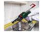Une personne utilise un pistolet à silicone Parkside dans une cuisine.
