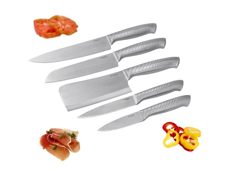 Cinq couteaux en acier inoxydable avec des manches gris, accompagnés de tomates, poivrons et prosciutto tranchés.