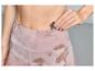 Une femme met une clé dans la poche de son legging rose.