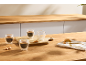 Tasses à expresso en verre à double paroi avec biscuits sur une table en bois.