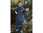 Un enfant portant un imperméable et un pantalon bleus Reima, dehors sous la pluie.