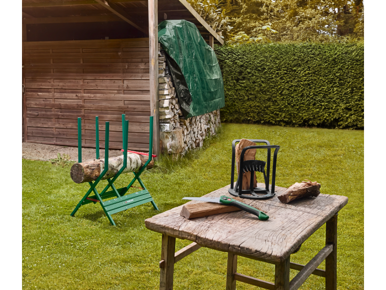 Chevalet de sciage et fendeur de bûches sur une table dans le jardin.