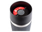 Une tasse isotherme noire avec un couvercle rouge de la marque Tefal.