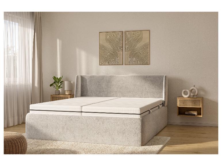 Un lit rembourré gris avec un matelas blanc dans une chambre à coucher moderne.