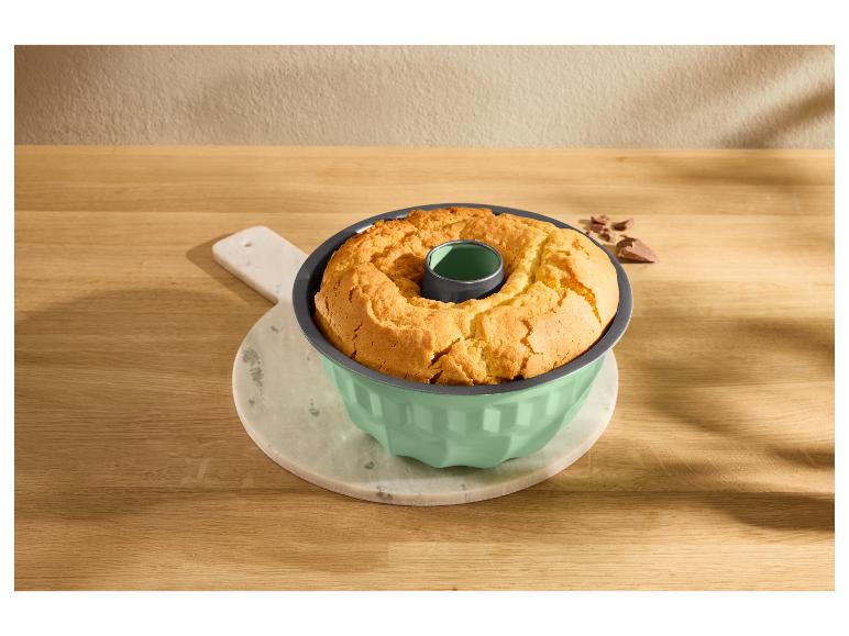 Gâteau Bundt doré dans un moule vert menthe sur une planche à découper en marbre.
