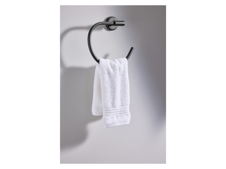 Une serviette accrochée à un porte-serviette noir.