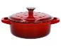 Cocotte rouge en fonte avec couvercle.