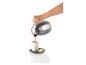 Une main verse du café d'une carafe isotherme dans une tasse.
