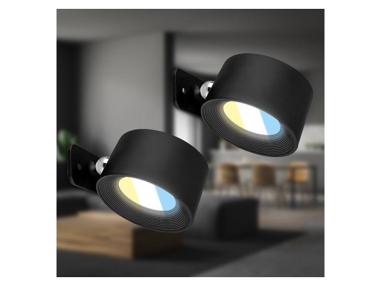 Deux spots muraux noirs avec lumière chaude et froide dans un intérieur moderne.