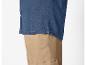 Chemise en jean bleu foncé et pantalon beige.