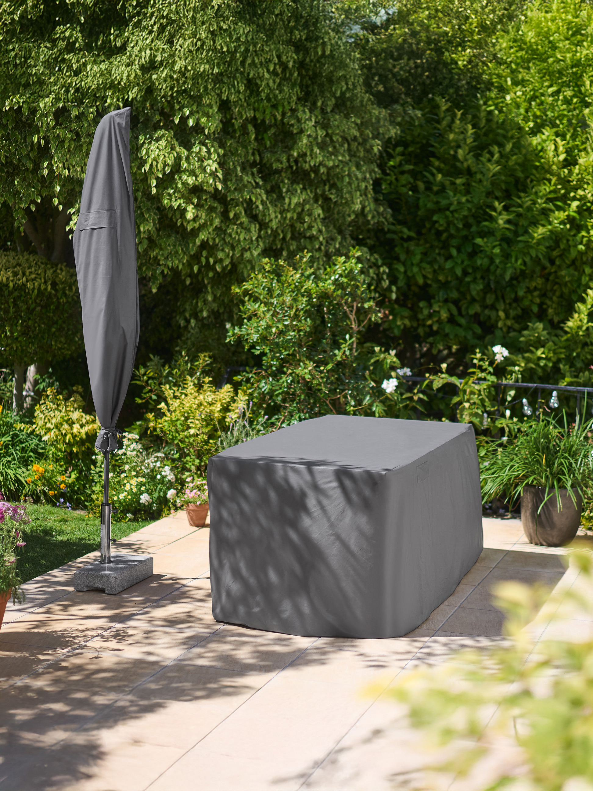 Housses de mobilier de jardin et de parasol dans un jardin.