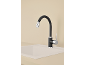 Robinet de cuisine noir avec bec flexible et évier beige.