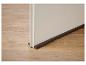 Boudin de porte marron sur un plancher en bois, bloquant l'espace sous la porte.