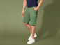 Un homme portant un short cargo vert et des baskets blanches.