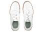 Une paire de baskets blanches en cuir avec des semelles beiges.