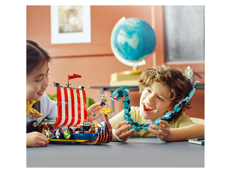 Deux enfants jouent avec des ensembles LEGO, un navire viking et un dragon bleu.