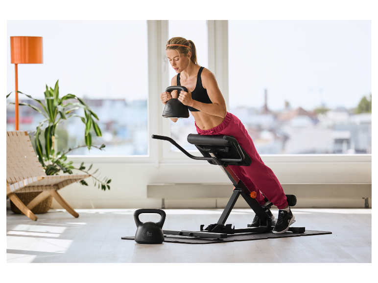 Femme s'entraînant avec un kettlebell CRIVIT de 6 kg et un banc à lombaires.