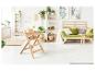 Chaise haute en bois dans un salon lumineux et végétalisé avec un canapé vert