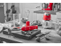 Appareils de cuisine rouges, dont un mixeur plongeant et un hachoir, sur un comptoir de cuisine.