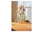 Des fleurs dans un vase en verre sur une table en bois