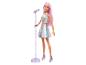 Poupée Barbie aux cheveux roses, avec un haut et une jupe argentés scintillants, et un pied de microphone violet.