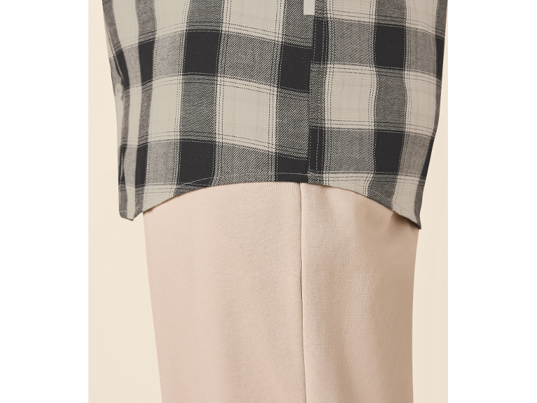 Chemise à carreaux et pantalon beige.