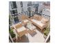 Ensemble de balcon en rotin avec canapé, deux fauteuils et table basse avec boissons.
