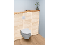 WC suspendu avec mur en bois clair et étagère, décoré d'un vase et d'une boîte.