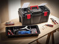 Une boîte à outils noire avec des outils et une petite boîte à outils rouge.